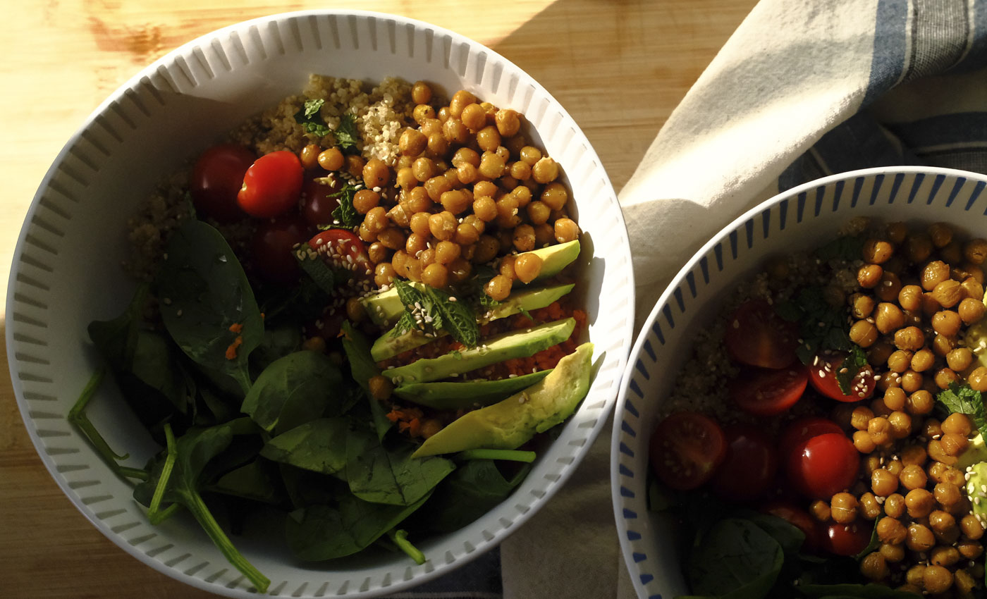 Frühlingshafte Quinoa-Bowl mit Avocado, Babyspinat, Kichererbsen und frischer Minze in einer hellen Schale serviert
